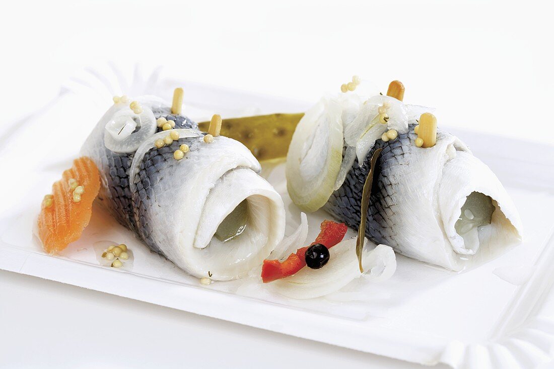 Two rollmops on a paper plate