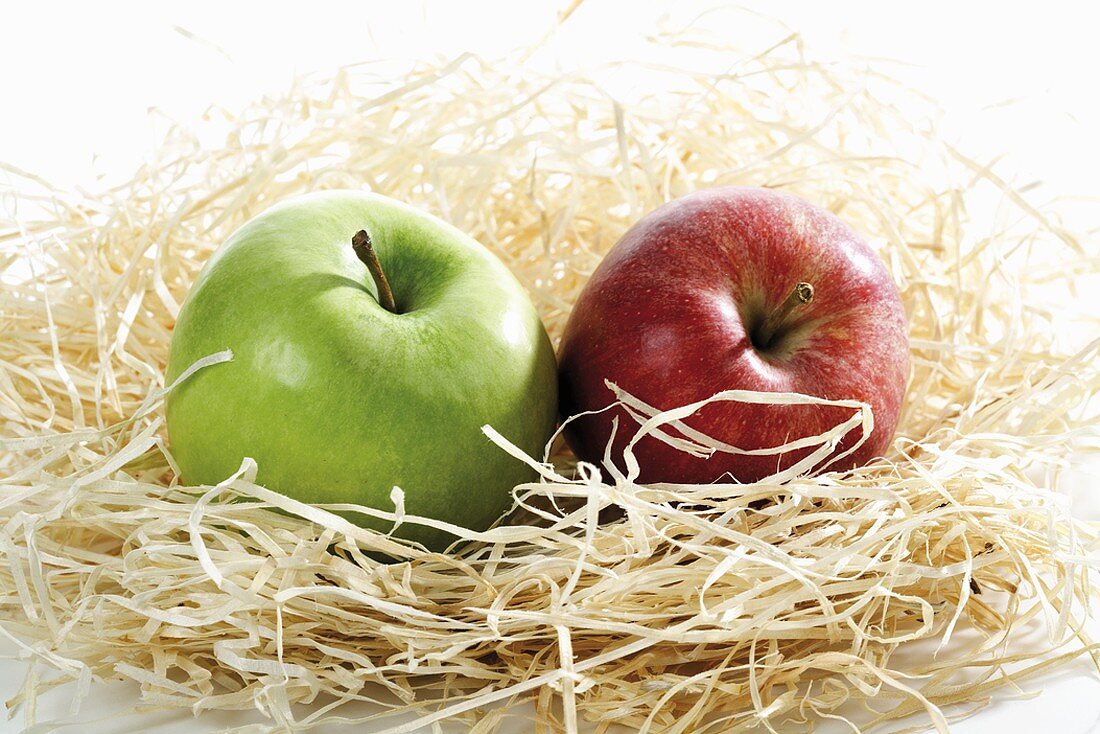 Two apples in a nest of wood wool