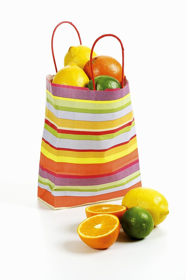 Citrus fruit in striped paper carrier bag