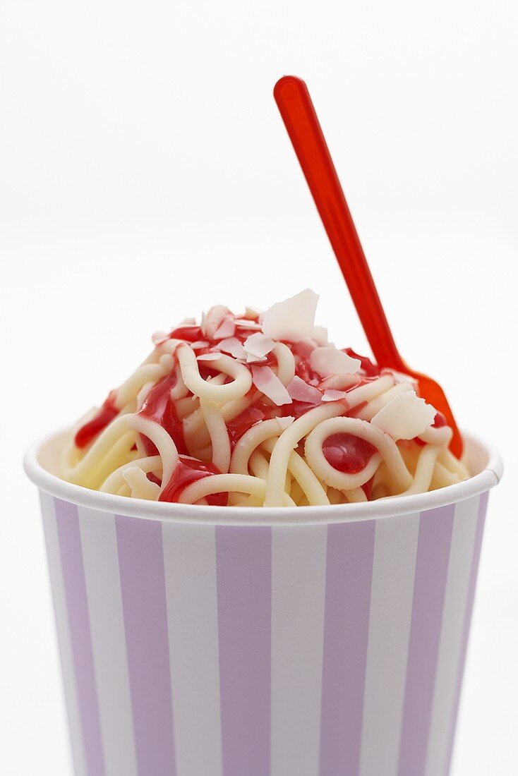 Ice cream spaghetti with strawberry sauce in tub