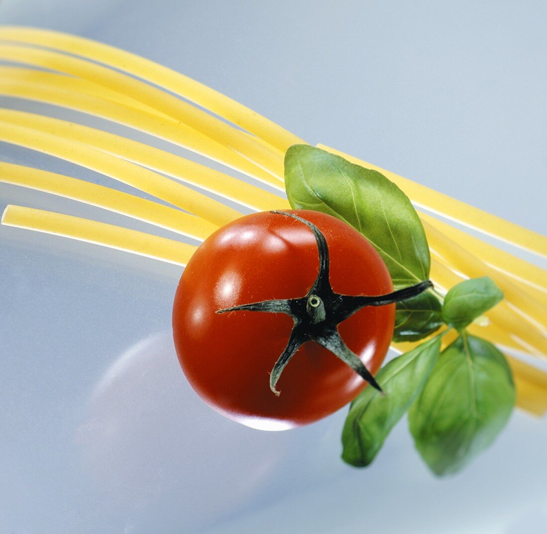 Spaghetti mit einer Tomate und Basilikum