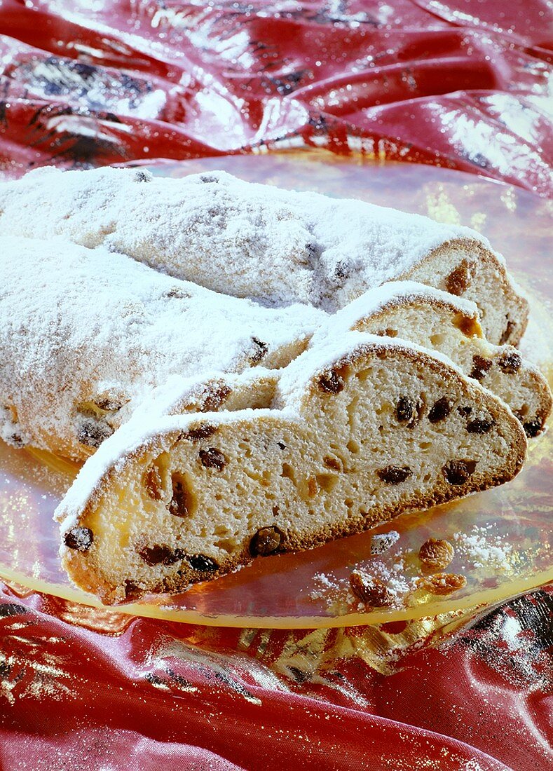 Stollen with icing sugar, partly sliced