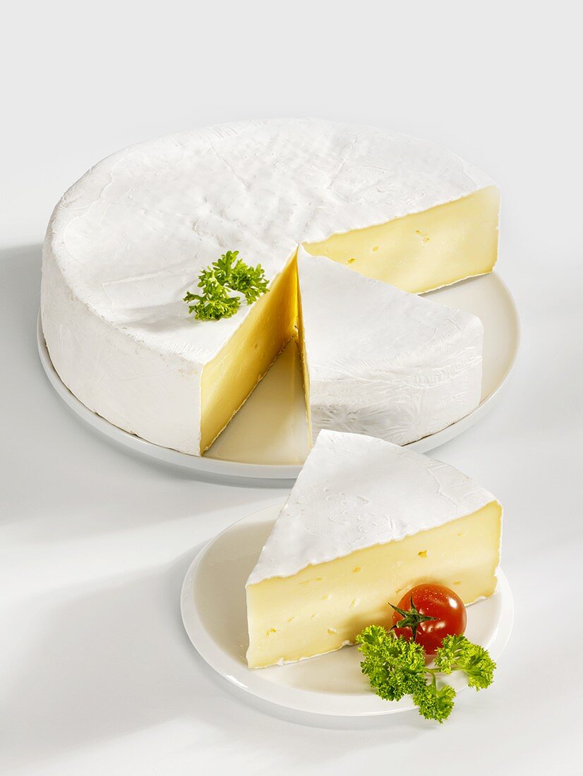 Angeschnittener Camembert mit zwei Käse-Ecken
