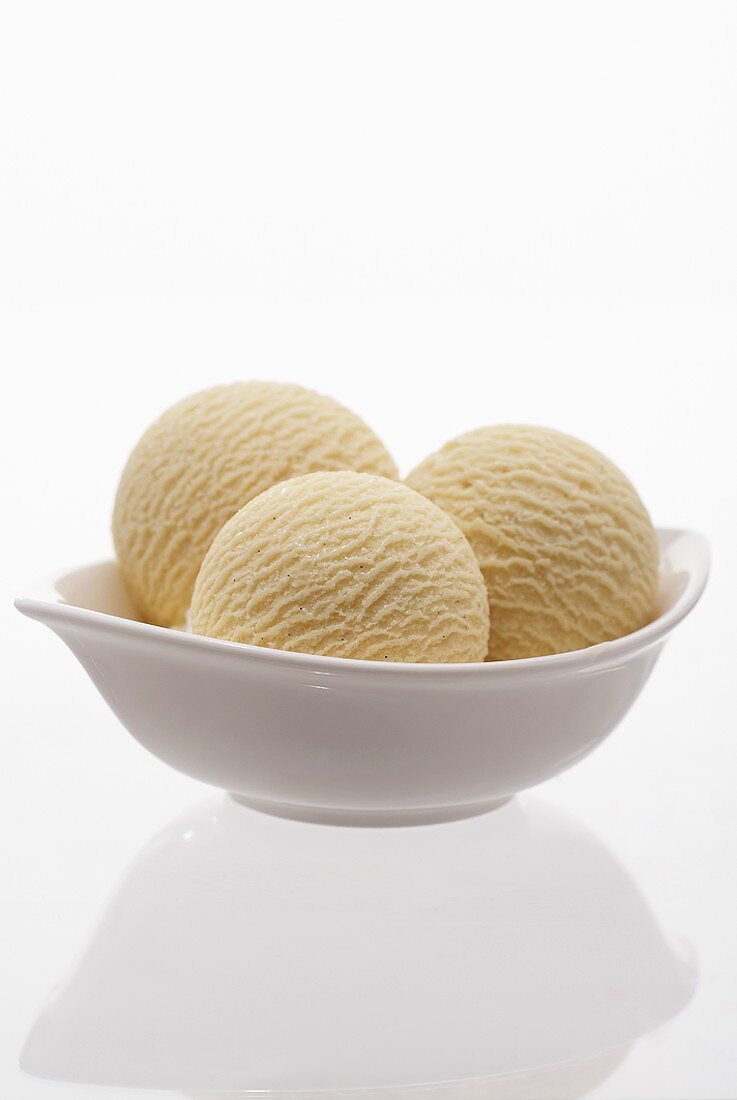 Three scoops of vanilla ice cream in a dish