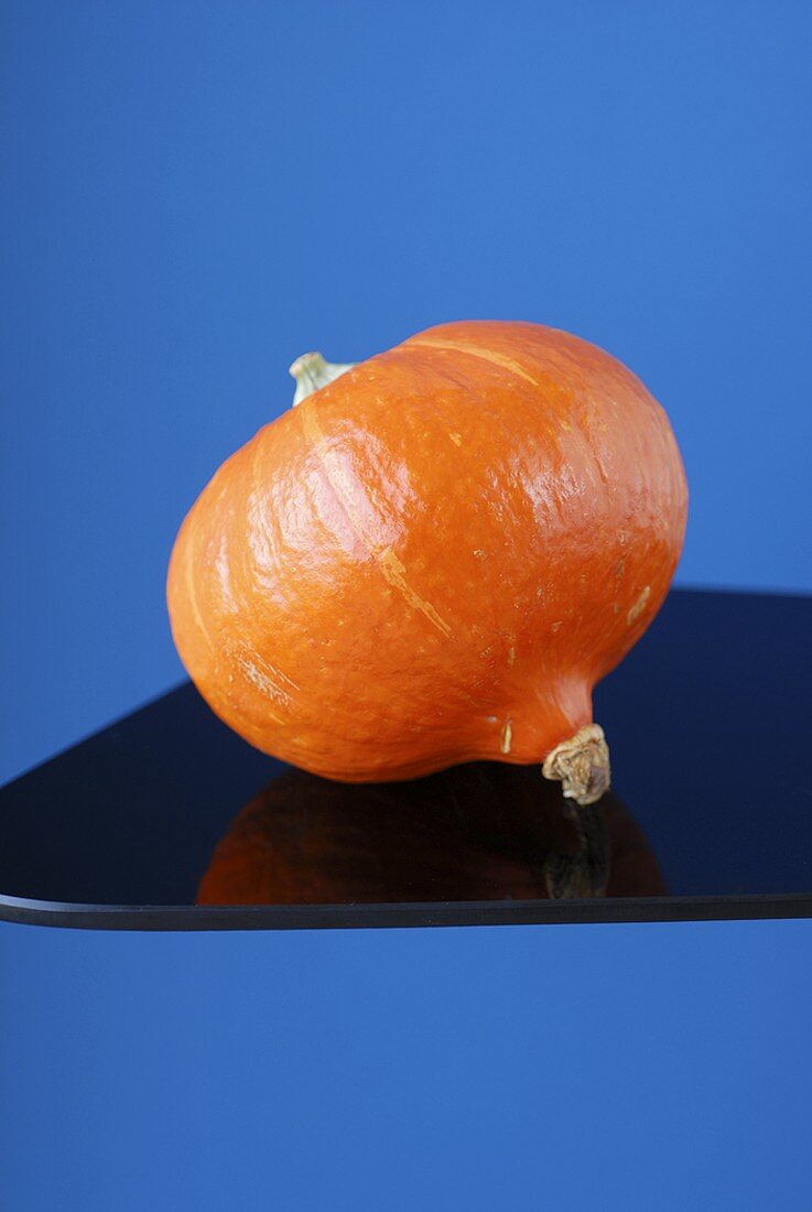 A Hokkaido pumpkin on a black platter