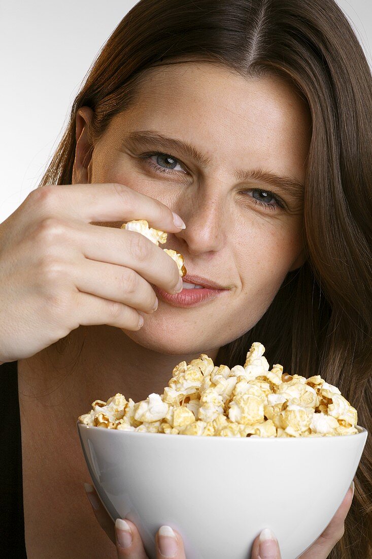 Junge Frau mit einer Schüssel Popcorn
