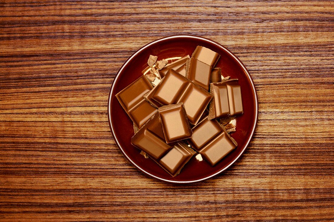 Pieces of chocolate on brown plate