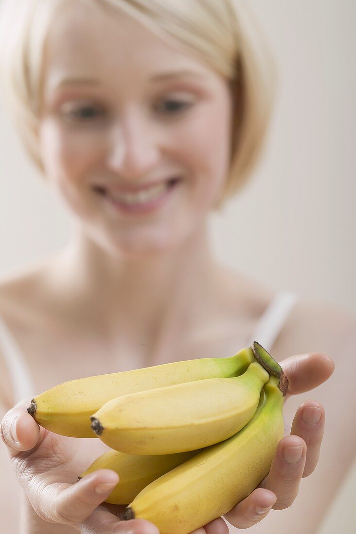 Junge Frau hält Bananen