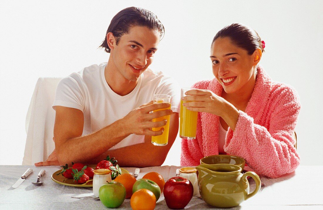 Couple eating breakfast of fruit and juice
