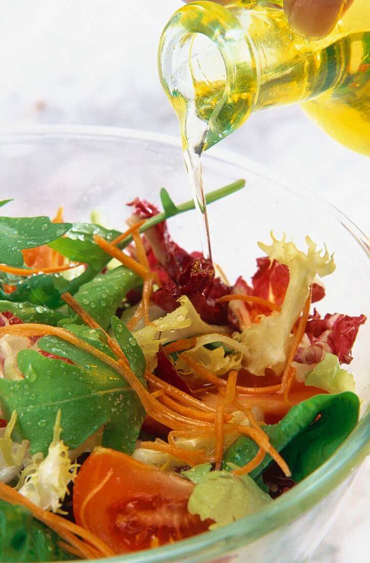 Ein gemischter Salat mit Olivenöl begiessen