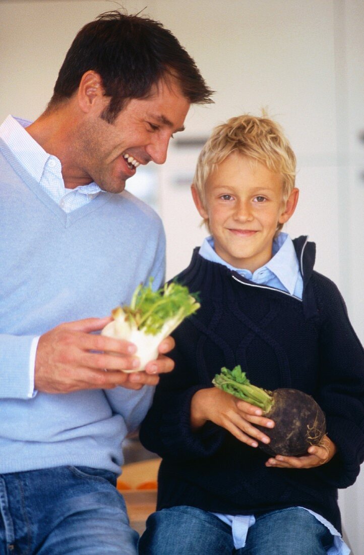 Father and son holding vegetables