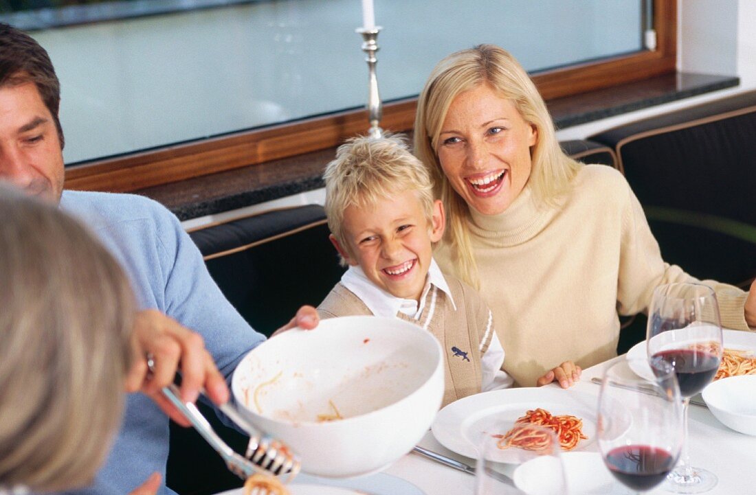 Family eating spaghetti with tomato sauce