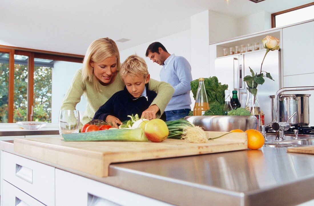 Family chopping vegetables in kitchen