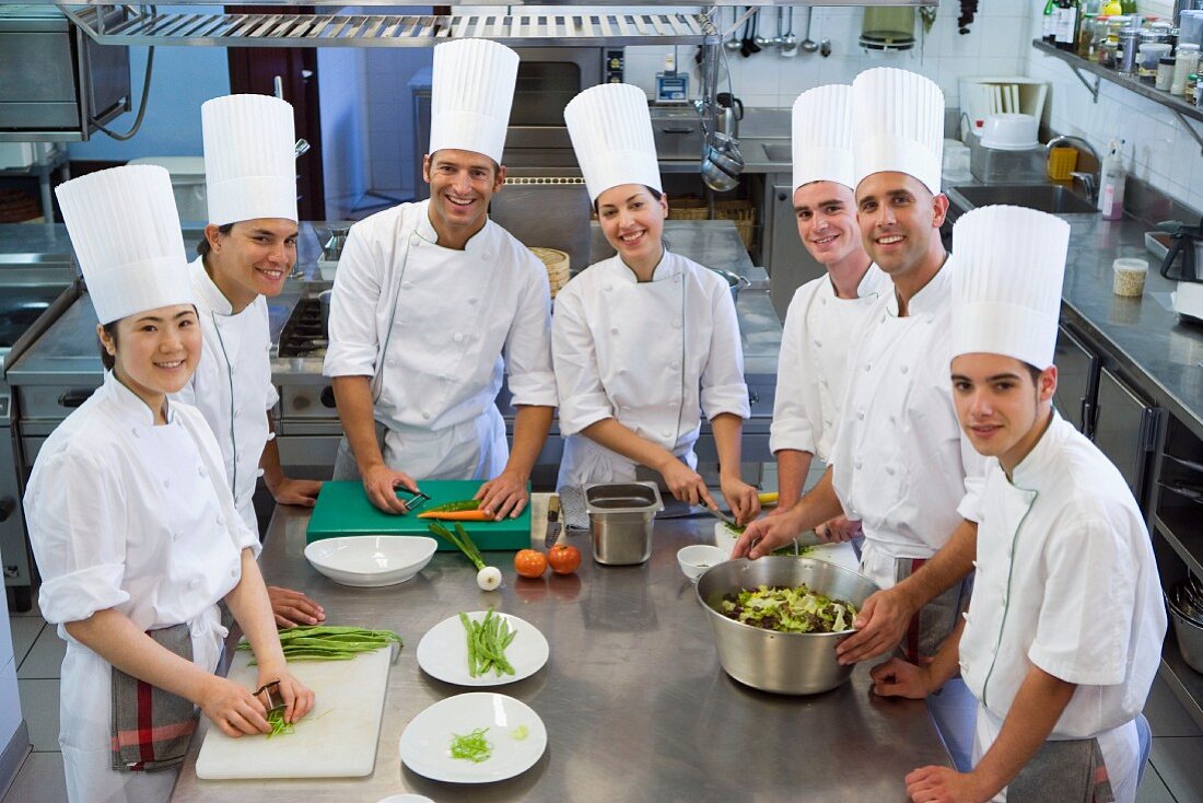 Chefs preparing vegetables in a commercial kitchen