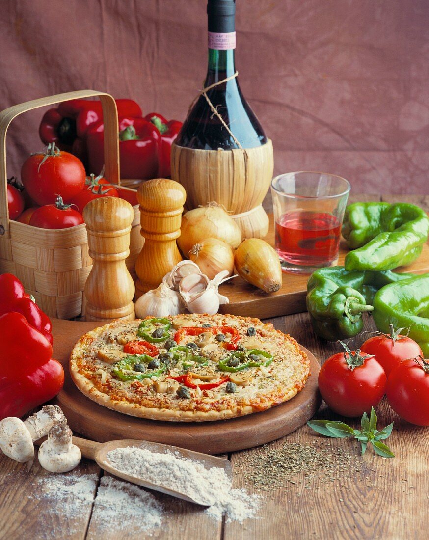 Gemüsepizza mit Zutaten und einer Flasche Wein
