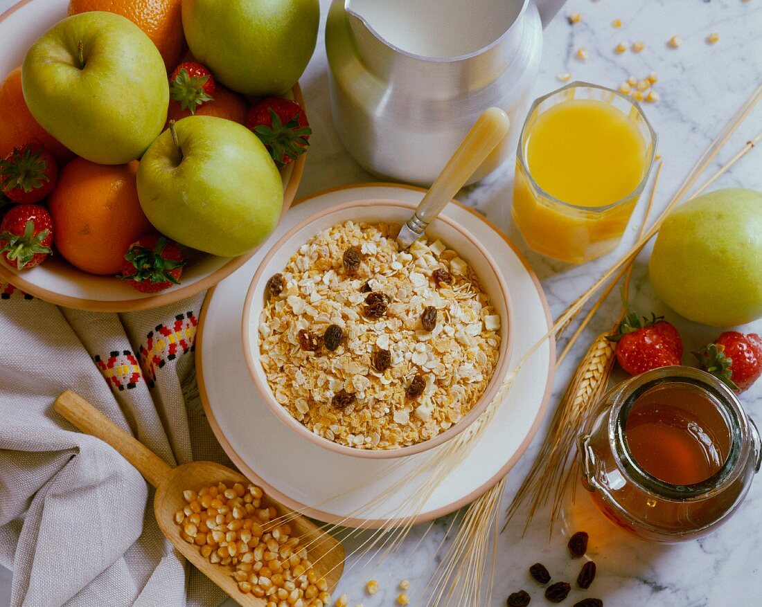 A healthy breakfast with fruit, juice, milk, muesli and honey