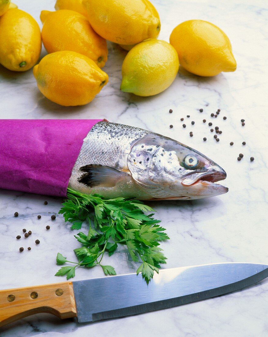 A whole salmon with lemons and a sharp knife