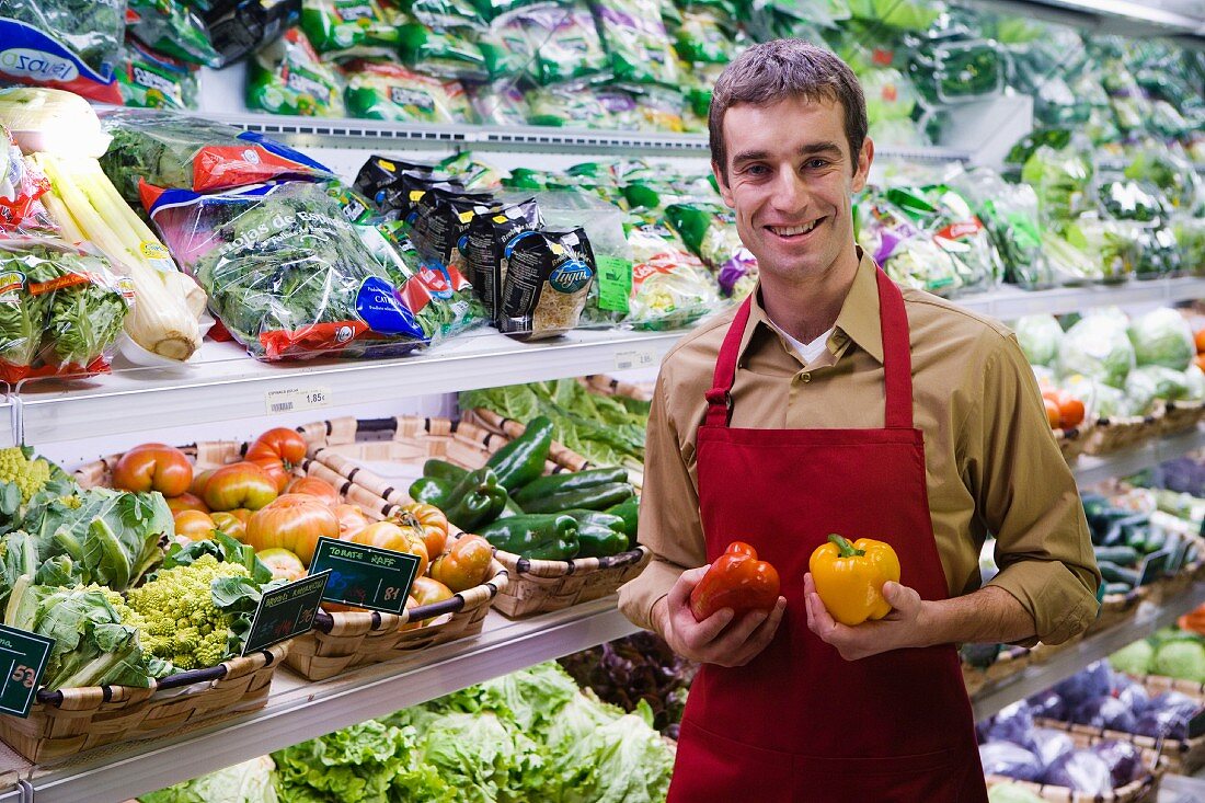Shop assistant in front of vegetable racks