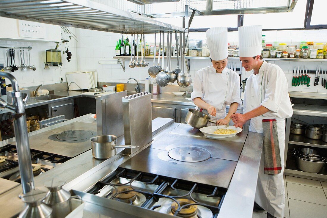 Chefs in a commercial kitchen preparing a salad