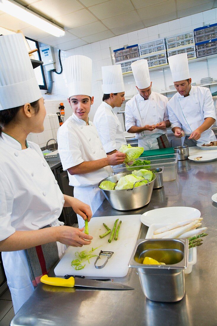 Chefs preparing salad in a commercial kitchen