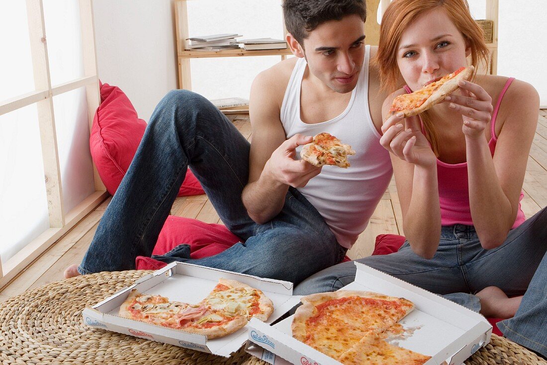 Couple eating pizza out of pizza box