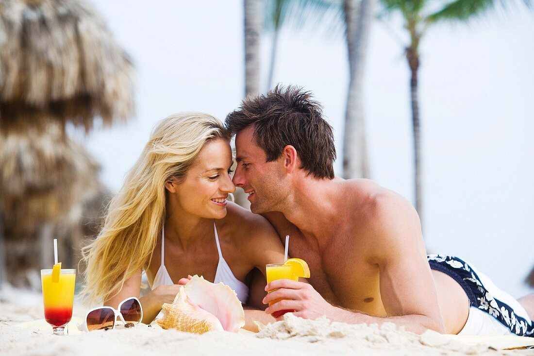 Paar macht Urlaub am Strand mit Cocktails