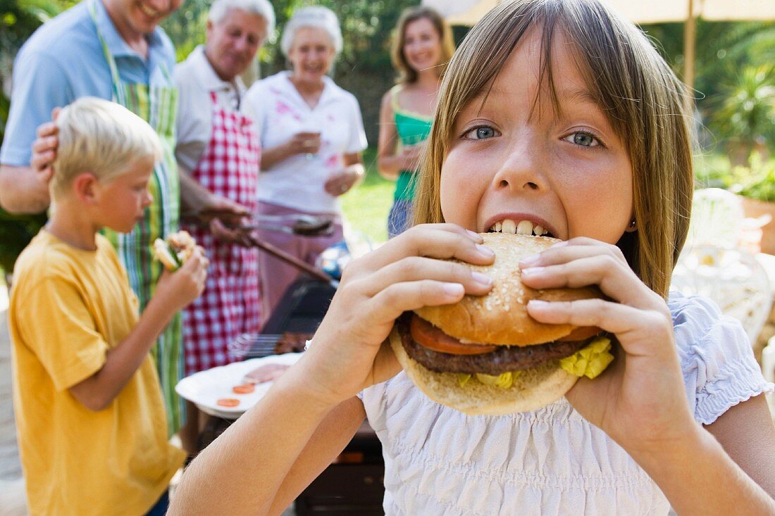 Girl biting into hamburger