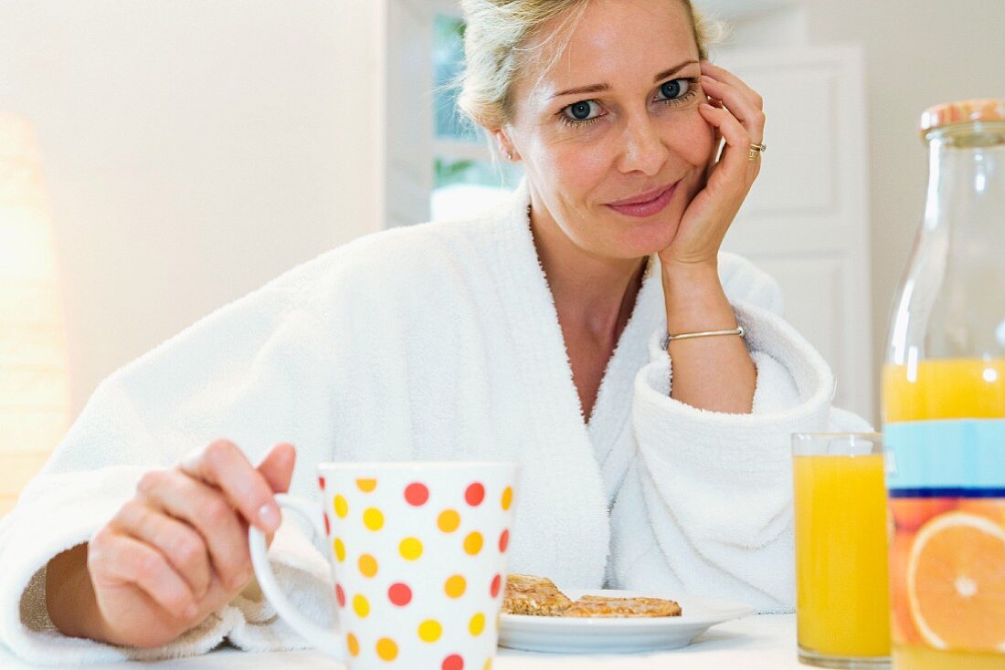 Woman eating breakfast in dressing gown