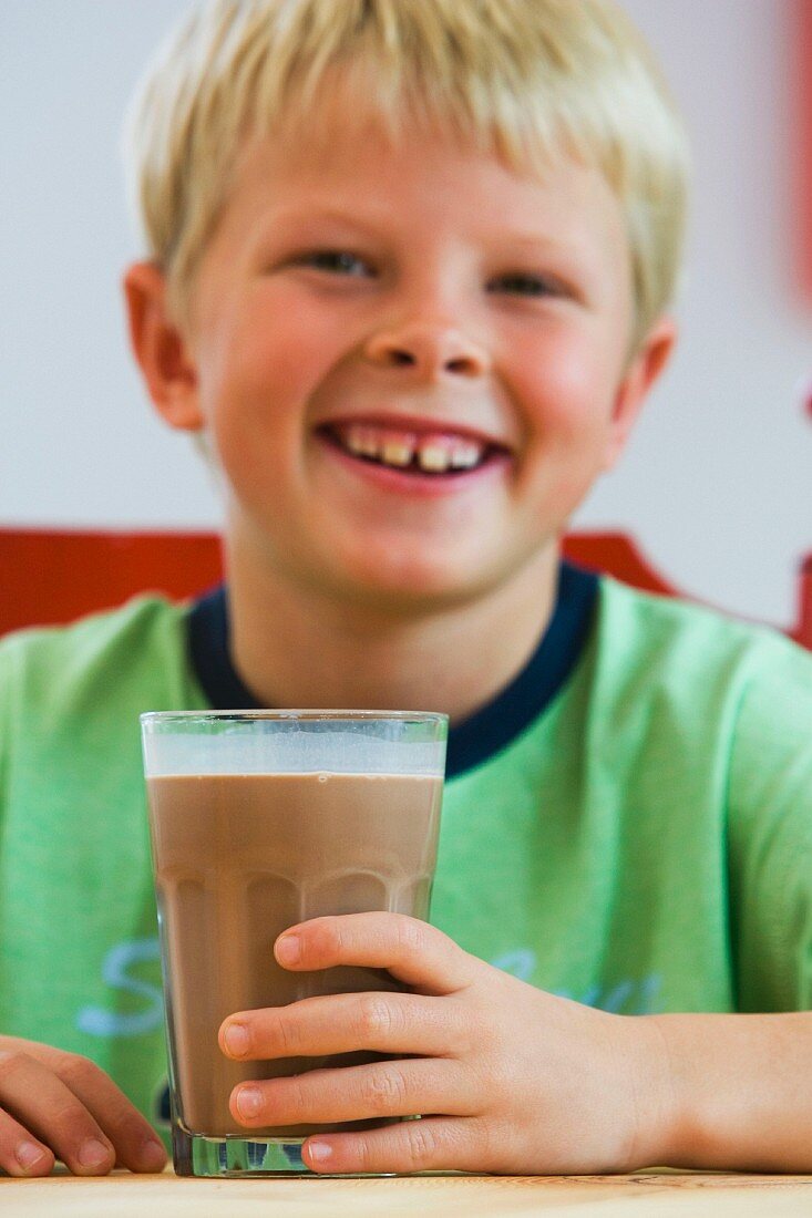 Junge mit einem Glas Schokolade