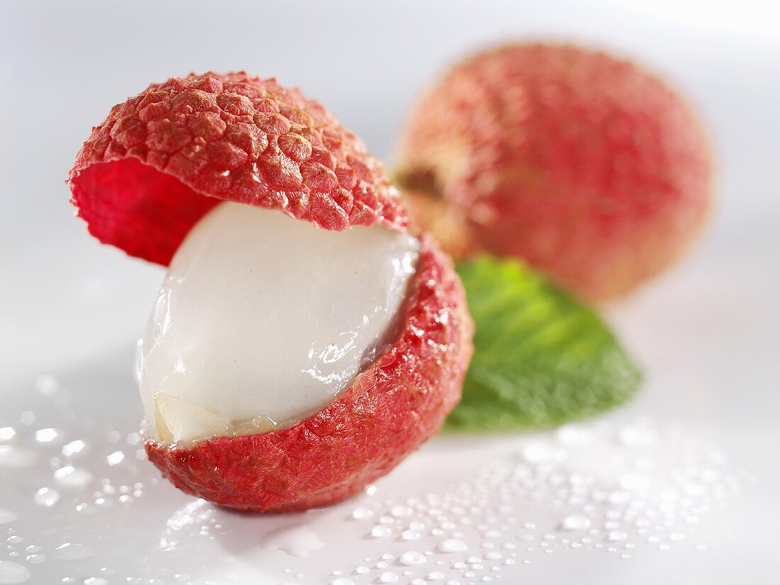 Two lychees, one with opened shell