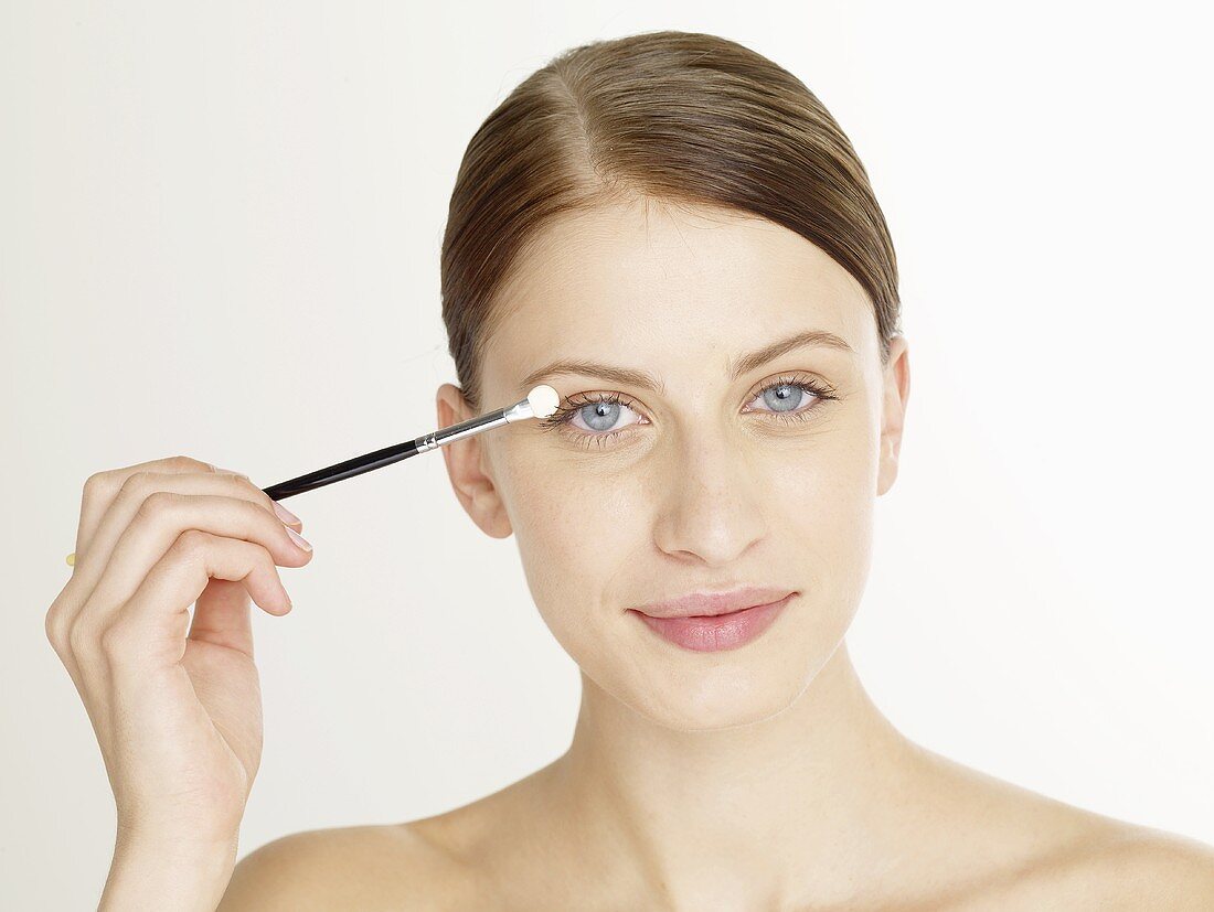 Woman putting on eye shadow