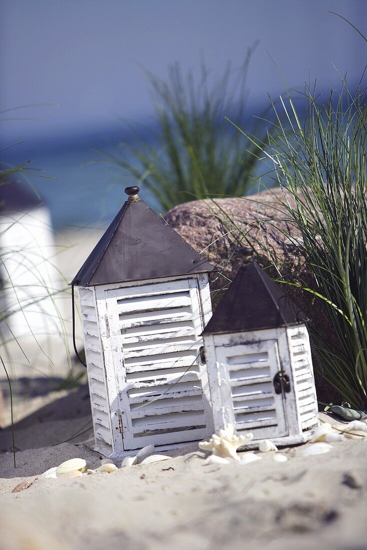 Zwei Windlichter am Meer mit Strandhafer