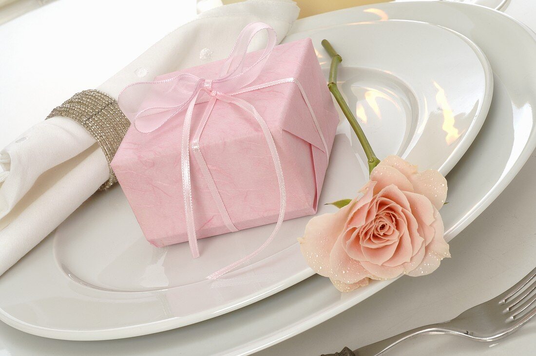 Tischgedeck mit rosafarbenen Geschenk
