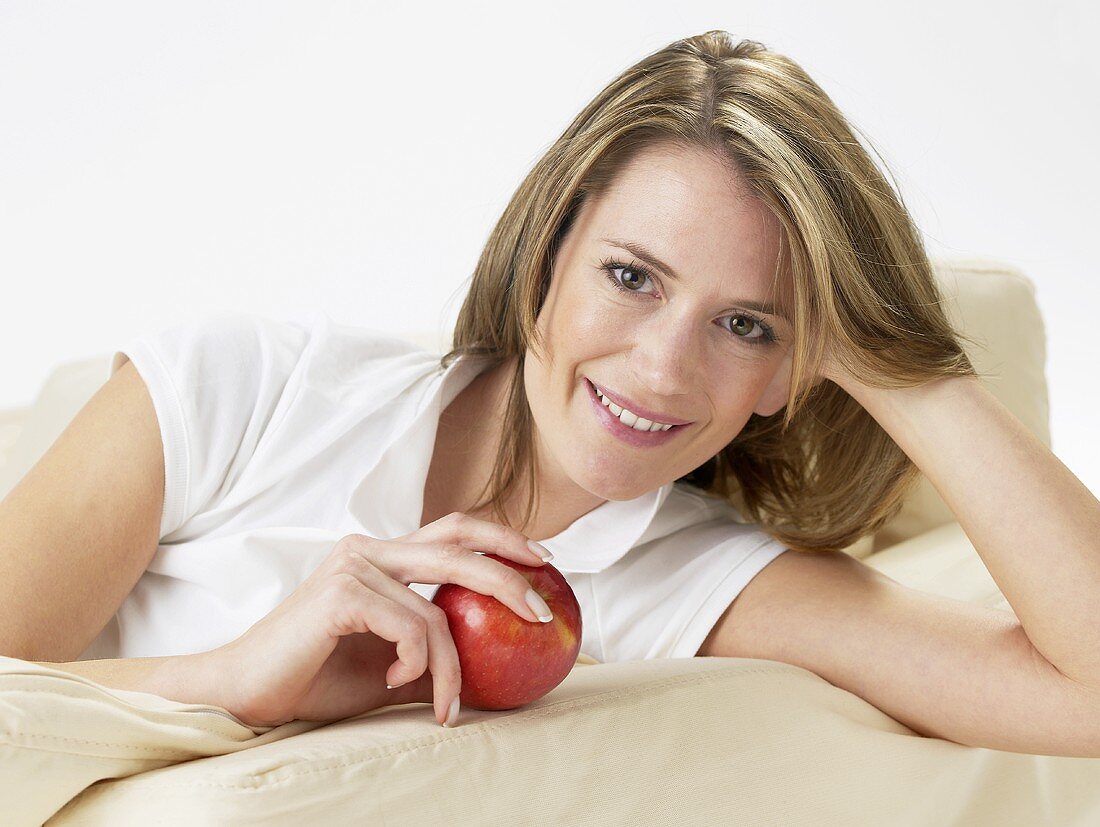 Woman on sofa with an apple