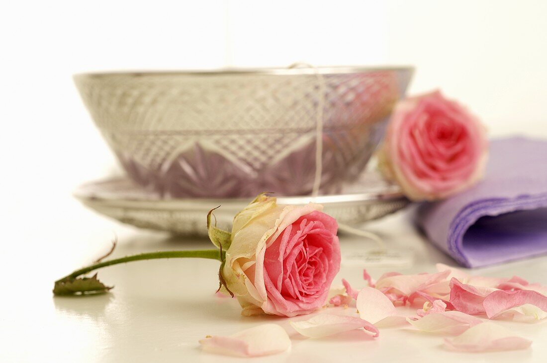 Silberne Teetasse und rosa Rosen