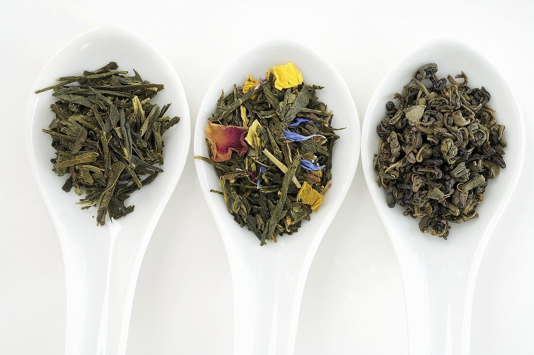 Drei verschiedene Teesorten in Porzellanlöffeln (Draufsicht)