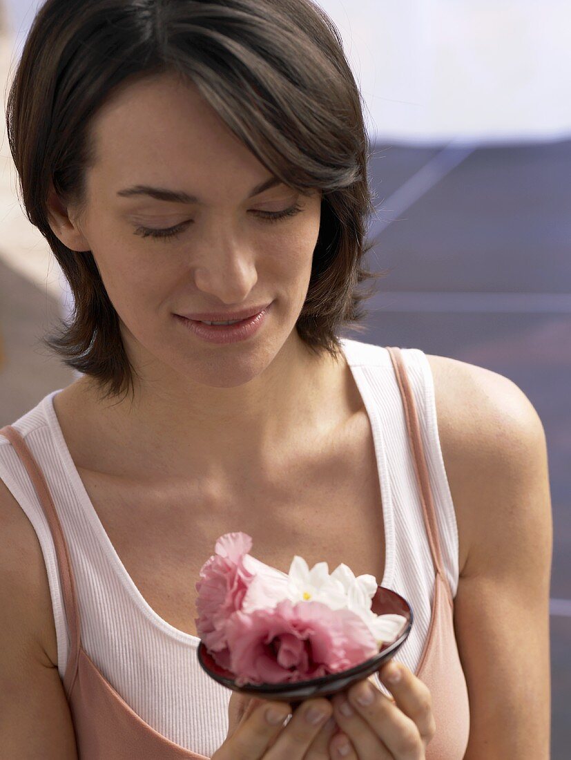 Woman with a small dish of flowers