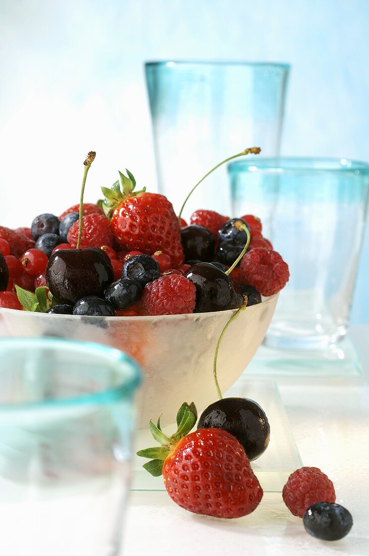 Beeren und Kirschen, umgeben von Gläsern