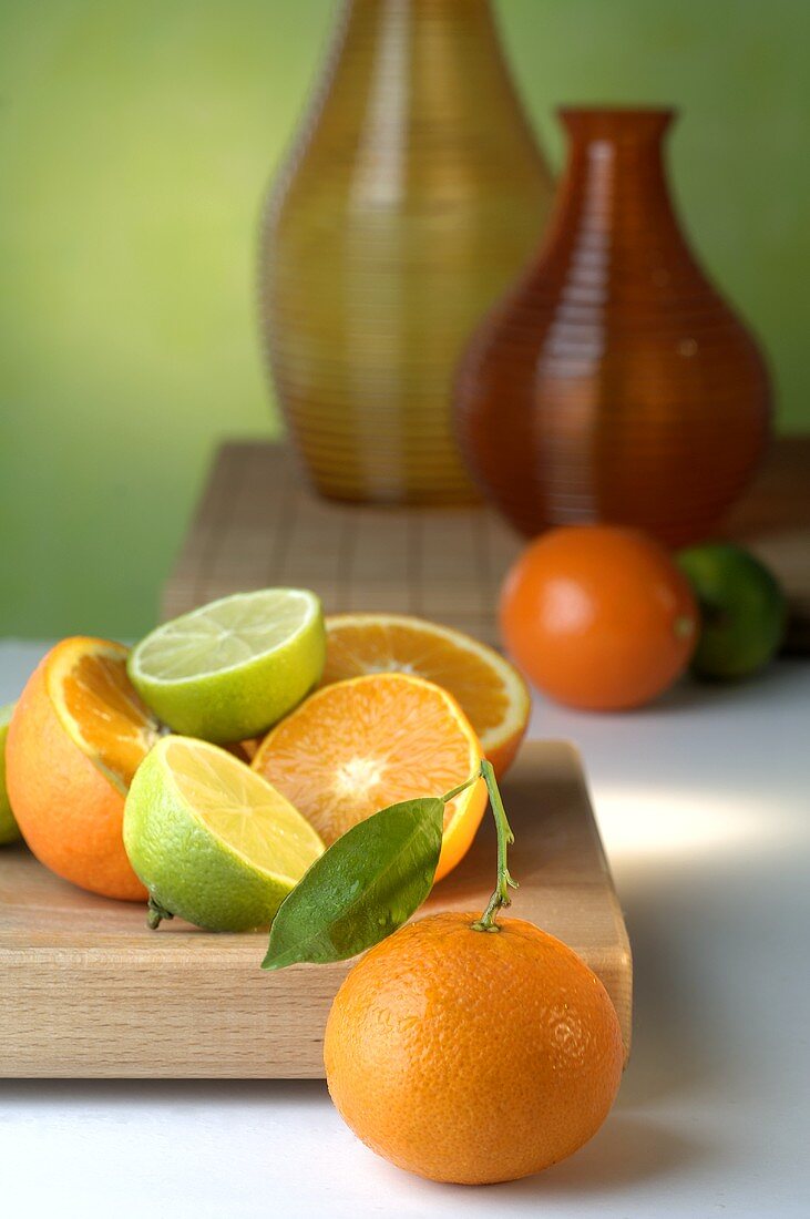 Oranges and limes on chopping board
