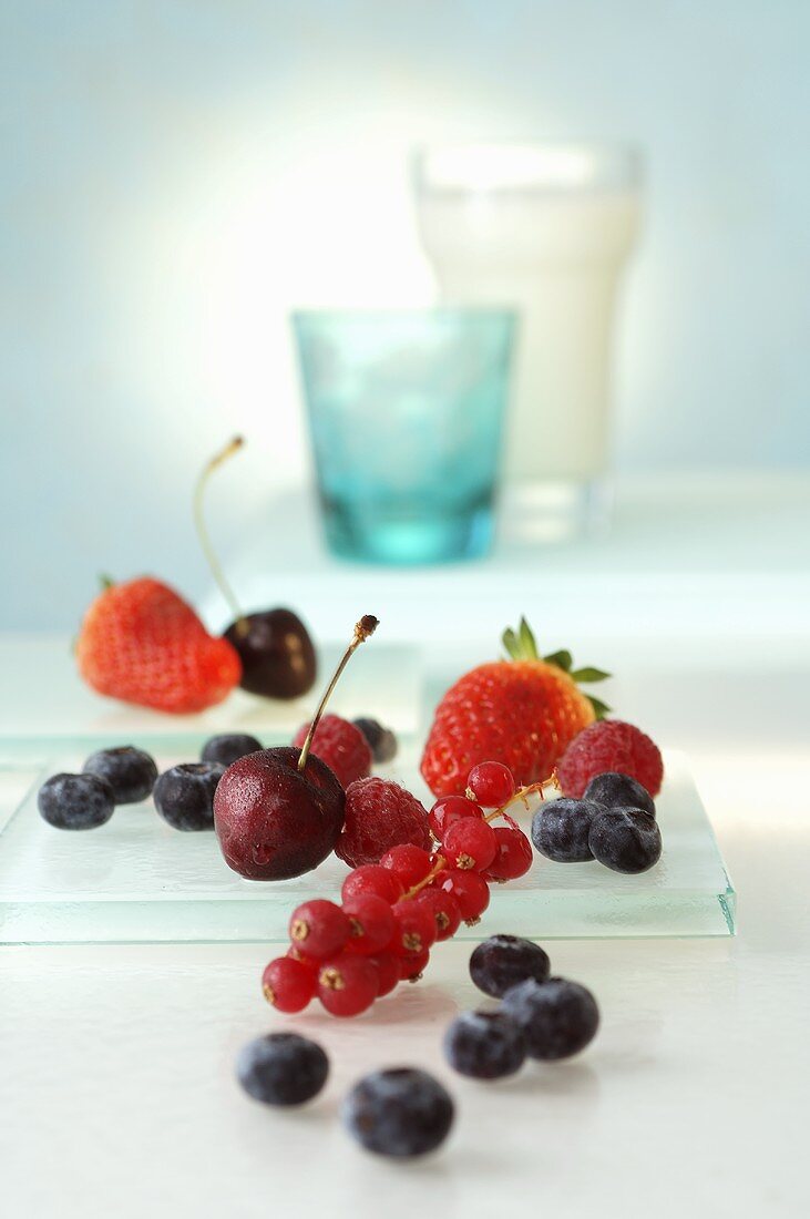 Berries and cherries, glasses in background