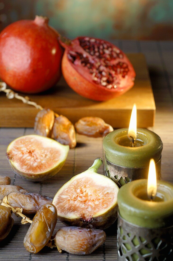 Pomegranates, figs and dates, two candles