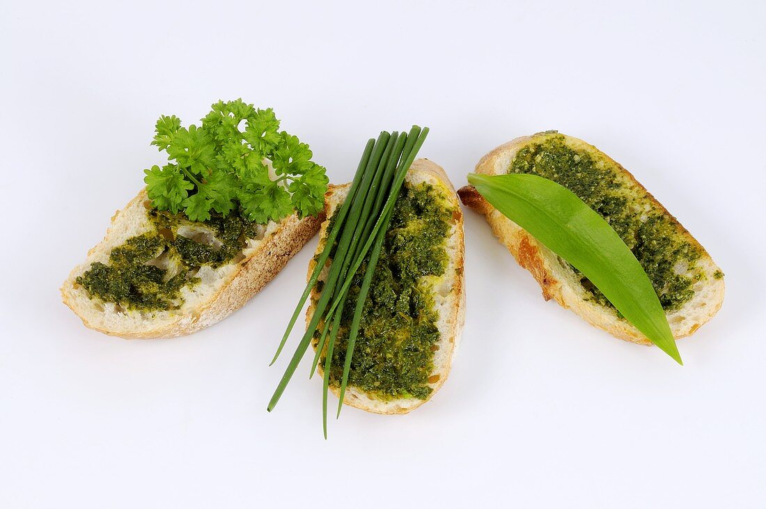 Three slices of bread with different pesto spreads