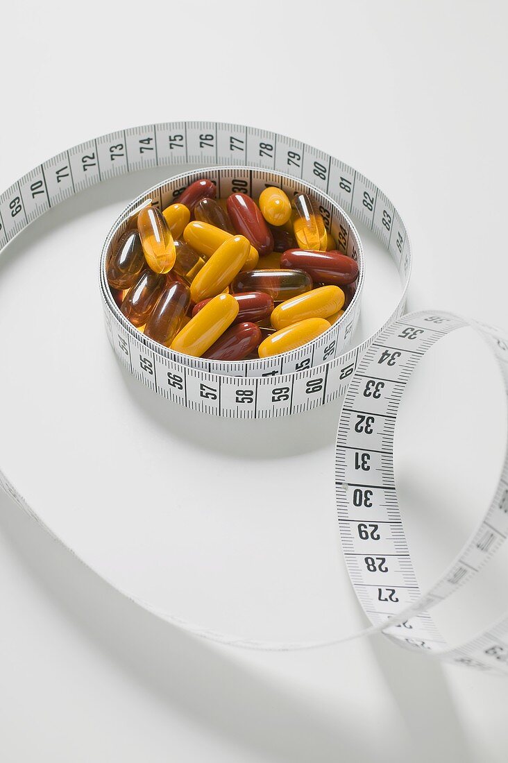 Assorted vitamin capsules and tape measure