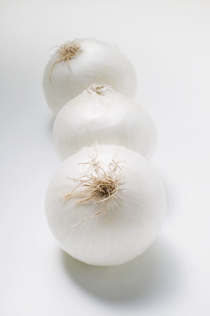 Three white onions in a row