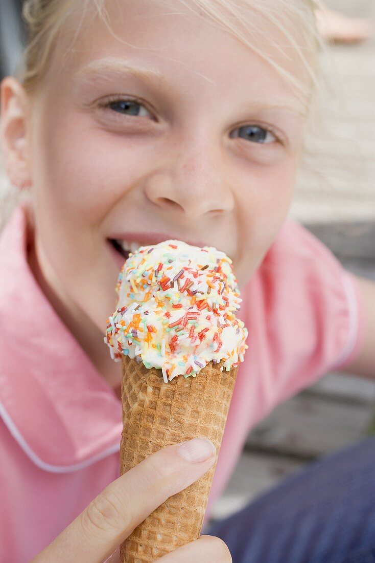Mädchen isst Eistüte mit Zuckerstreuseln