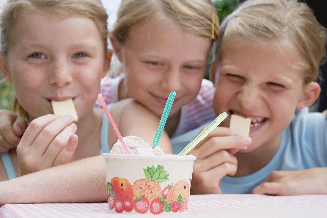 Drei Mädchen mit Eisbecher und Waffeln