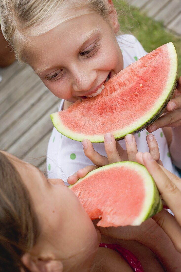 Two girls eating watermelon