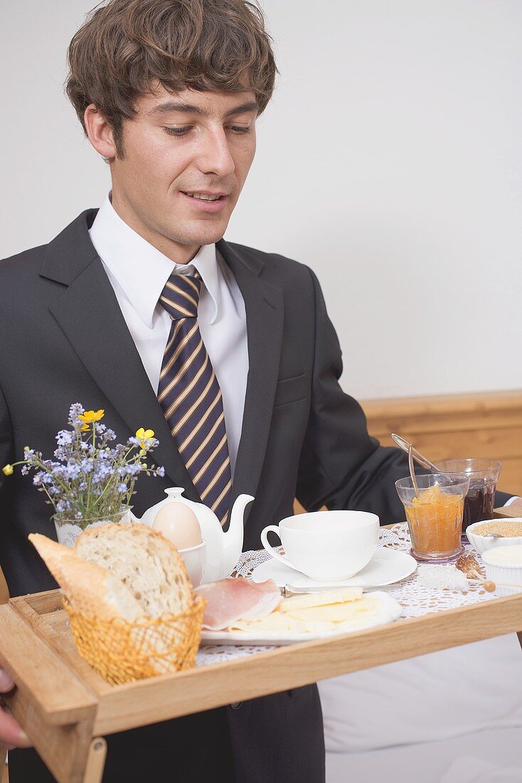 Man holding breakfast tray