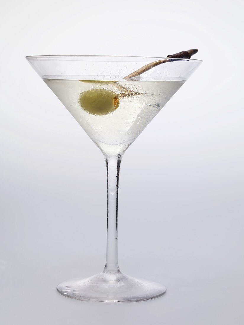 Martini with green olive in glass