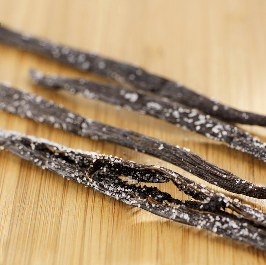 Four vanilla pods with vanilla sugar